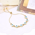 Adjustable gold bracelet featuring heart-shaped evil eye charms with micro-pave zircons - White