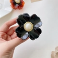 Pinza per capelli a fiore nero lucido con perla centrale e base a spirale dorata - Nero