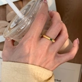 Close-up of a vintage brushed gold ring featuring a green emerald gemstone on finger - Brushed Emerald