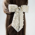 Elegante fiocco per capelli da sposa con perle bianche e strass su capelli scuri - Bianco