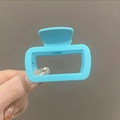 Light blue matte square hollow claw clip for thin hair shown in a hand-held view - Matte Blue