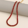 18K gold plated tennis necklace with vibrant red zircon stones on a gray pedestal - Gold-Red / Necklace