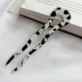Detailed close-up of wave-shaped acetate U-shaped hair pin with black and white marble pattern - Black and White