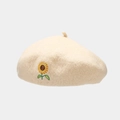 Close-up of beige wool beret featuring intricate sunflower embroidery and textured knit - Beige