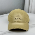 Detailed macro view of distressed fabric and em embroidery on mustard baseball cap - Khaki