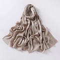 Detail of champagne gold bubble chiffon hijab featuring handcrafted rhinestone floral accents - Camel
