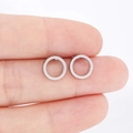 Detailed macro view showing the size and metallic luster of silver stainless steel hoop earrings - Silver