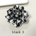 Detail of handmade houndstooth camellia brooch with layered black and white fabric petals - Black and White Houndstooth