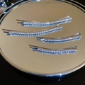 Dettaglio di quattro fermagli per capelli in argento con strass su un vassoio a specchio riflettente - Argento Stile 2 (Set da 4)