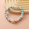 Colorful beaded bracelet featuring blue, white, red beads and white turtle charm - Blue White Red Splatter White Turtle Bracelet