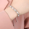 Verstellbares Perlenarmband in Silber mit Zirkonia-Zylindern am Handgelenk einer Frau - Pavee-Zirkonia-Stil (E421) / Stahlfarbe