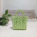 Detailopname van groen-wit geweven handtas met fijne texturen op een witte tafel - Mini Groen Contrast