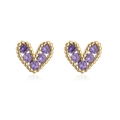 Macro detail of gold-plated heart earrings featuring sparkling purple zircon stones - Purple