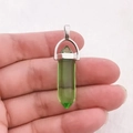 Gedetailleerd macrobeeld van een zeshoekige groene kristallen hanger met zilveren borg - Transparant Groen