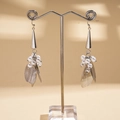 Detail view of pearl petal tassel earrings featuring brushed metal leaves and silver finish - Silver