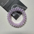 Spiral phone cord hair tie in transparent purple design on a display card - Polka Dot Purple