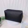 Black textured square makeup bag with gold zippers and pearl letter accents on white stand - Large / Black