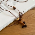 Detail der Bärenhalskette aus Holz mit Kaffeebohnen auf antiken Buchseiten dekoriert - Halskette-Braun-Bär