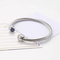 Silver twisted cable cuff bracelet featuring a faceted round blue zircon stone setting - September/Deep Blue