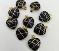 Detail view of heart-shaped black agate pendants with intricate gold wire wrapping details - Natural Obsidian