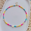 Detailopname van kleurrijke Heishi-kralen en madeliefjes op een boho-stijl ketting - Kleurrijke Madeliefjes