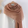 Solid cinnamon brown cotton linen scarf with pleated texture and frayed edges on a hanger - Cinnamon