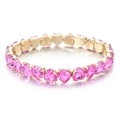 Macro view of heart-shaped pink zircon stones set in a gold plated tennis bracelet - Bright Pink