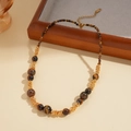 Détail macro de perles œil de tigre et chaîne dorée avec fermoir mousqueton et rallonge - Collier-Perle Ronde Café