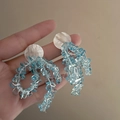 Detail of handmade bow drop earrings featuring blue crystal beads and shell texture - Bow Tassel / Silver Earring Post-Blue