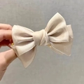 Elegante pinza para el pelo con lazo de seda champán y textura satinada para moños - Champán