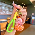 Gros plan d'un porte-clés cochon rose avec flacon de paillettes et dragonne verte - Cochon Pêche Flocon de Neige Lumineux Orange