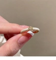 Macro detail of gold open ring with cream enamel finish and a rectangular zircon stone - Cream White