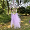 Purple Tree of Life dream catcher with white crystals and soft feathers outdoors - Light Amethyst