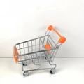 Detailed side view of a mini orange shopping cart model for desk storage and pretend play - Orange