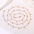 Macro shot of gold butterfly necklace with crystal beads on a soft white fabric background - Butterfly Crystal Chain
