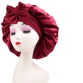 Close-up of a dark red satin sleep cap featuring a large decorative bow and elastic rim - Cross-Wine Red