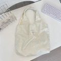 Flat lay of a mint green tote bag with cat prints and a branded woven label detail - Printed Cat Green