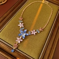 Dettaglio della collana floreale vintage con cristalli blu su cuscino in velluto - Viola-Blu