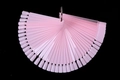 Pale pink plastic fan-shaped nail polish display sticks with a metal ring on black background - Ring Decor Style / Pink