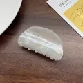 Iridescent multicolored acetate hair claw clip with wave patterns on dark wood table - Semi-circular Off-white