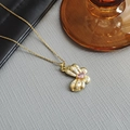 Detail of a golden butterfly pendant featuring a pink drop-shaped gemstone and white zircons - Bowknot Necklace-Gold 0384J