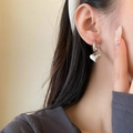 Silver metal heart hoop earrings worn by a model in a stylish French vintage aesthetic - Silver