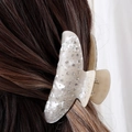 Detail van een parelwitte haarklem met strass-steentjes gedragen op bruin haar - H217 (Parelmoer Witte Vlinder Haarklem)