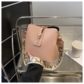 Details einer rosa Eimertasche aus Leder mit goldenen Beschlägen und breitem Gurt - Rosa