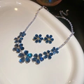 Dettaglio del set di gioielli a fiore in zircone blu con collana e orecchini a perno - Set Collana e Orecchini Blu