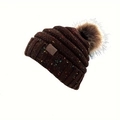 Détail d'un bonnet en maille épaisse avec mouchetures colorées, pompon et patch - Café