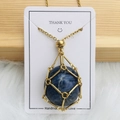 Golden mesh cage necklace with deep blue oval gemstone pendant on white card - Gold Blue Vein Stone