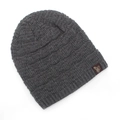 Détail du bonnet en maille gris foncé avec étiquette logo cygne marron et texture de tricotage - Gris