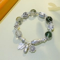 Ethnic beaded bracelet featuring green ghost crystal beads and silver fish pendants - 12mm Green Ghost: Fortune Fish Instant Wealth