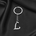 Stainless steel keychain with polished silver letter L pendant on black silk fabric - L
